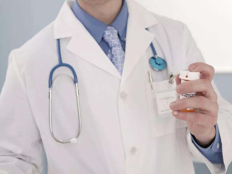Lekarz z opakowaniem tabletek w dłoni
